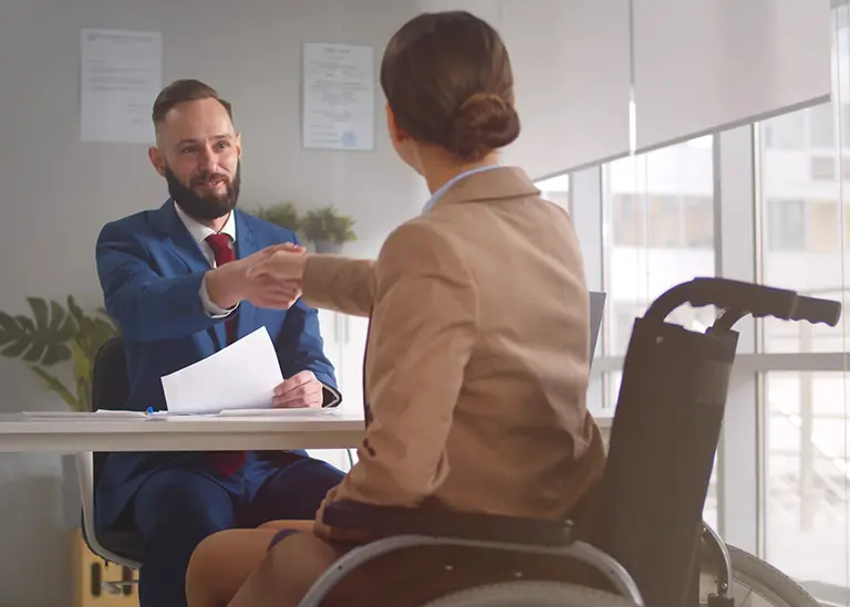 A clinical negligence solicitor helps a woman in a wheelchair