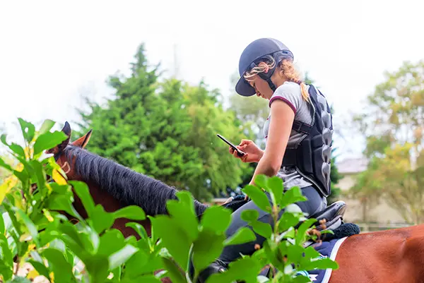 A woman riding a horse on a road